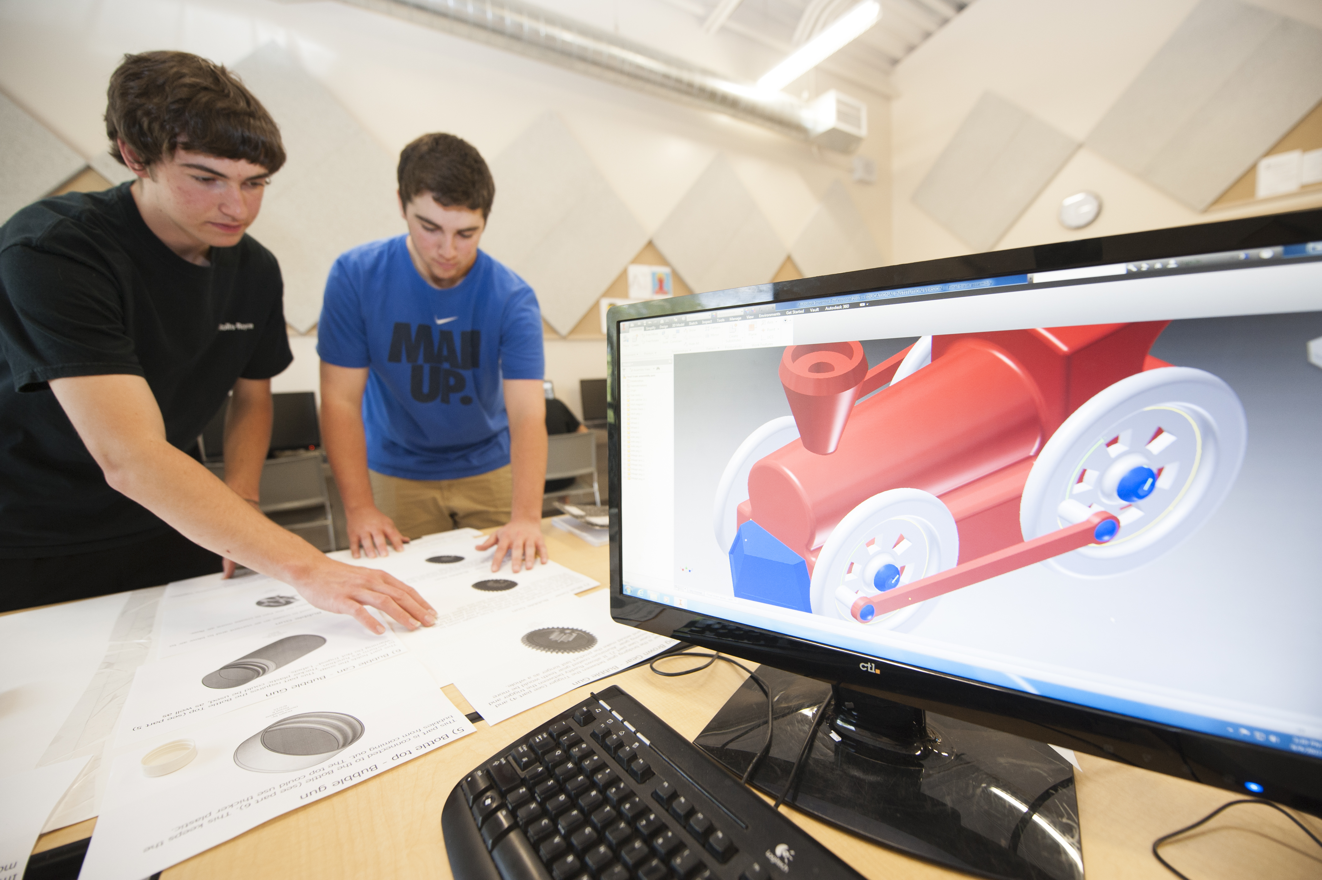 Students looking at a printout of a CAD design