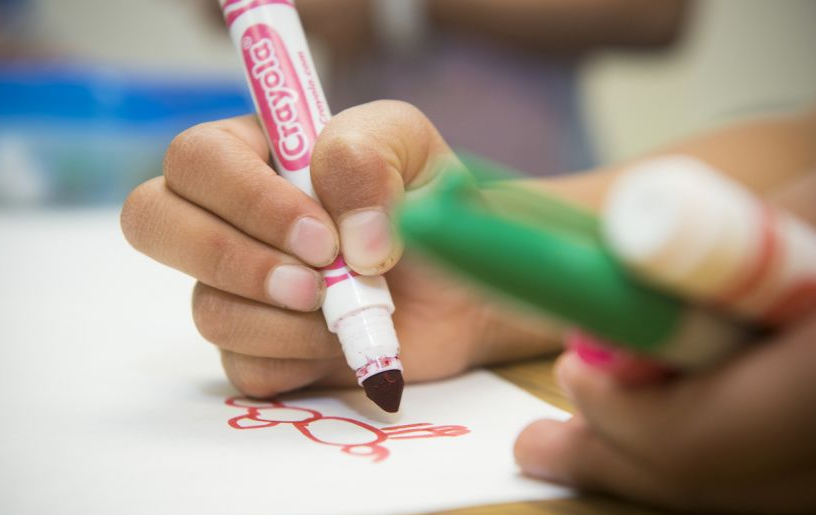 Student coloring with marker